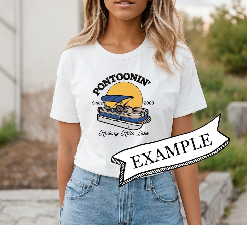 K&ouml;nnte beinhalten: Wei&szlig;es T-Shirt mit einem Aufdruck eines Pontonboots auf einem See mit dem Text "Pontoonin' Since 2000 Hickory Hills Lake". Das Shirt wird von einer Person getragen.