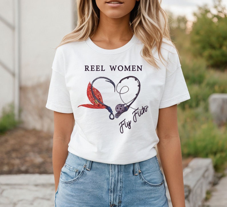 May include: White t-shirt with the text "Reel Women Fly Fish" and a graphic of a fishing hook and fly in the shape of a heart.