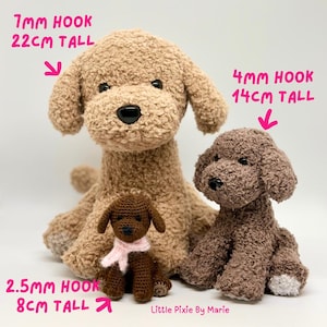 May include: Three crocheted plush dog toys in different sizes. The largest dog is beige and measures 22 cm tall. The middle dog is brown and measures 14 cm tall. The smallest dog is brown and measures 8 cm tall.  The text "Little Pixie By Marie" is visible at the bottom of the image.