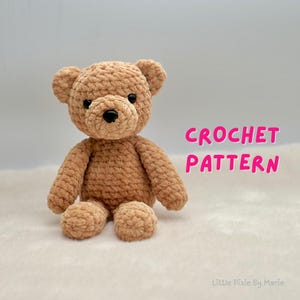 May include: A crocheted teddy bear in a light brown color. The bear has a round head, small ears, and a black nose. The text "CROCHET PATTERN" is displayed in pink. The bear is sitting on a white surface.