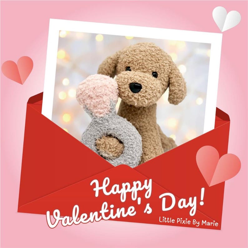 May include: A red envelope with a photo inside of a brown plush dog holding a pink and gray plush ring. The photo has a white border and the text "Happy Valentine's Day! Little Pixie By Marie" is below the photo.