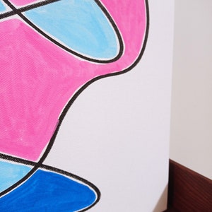 May include: Abstract art painting on canvas with pink, blue, and black shapes.