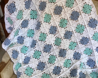 Handmade crochet blanket in mint and blue on a white background. Playmat sofathrow leg blanket