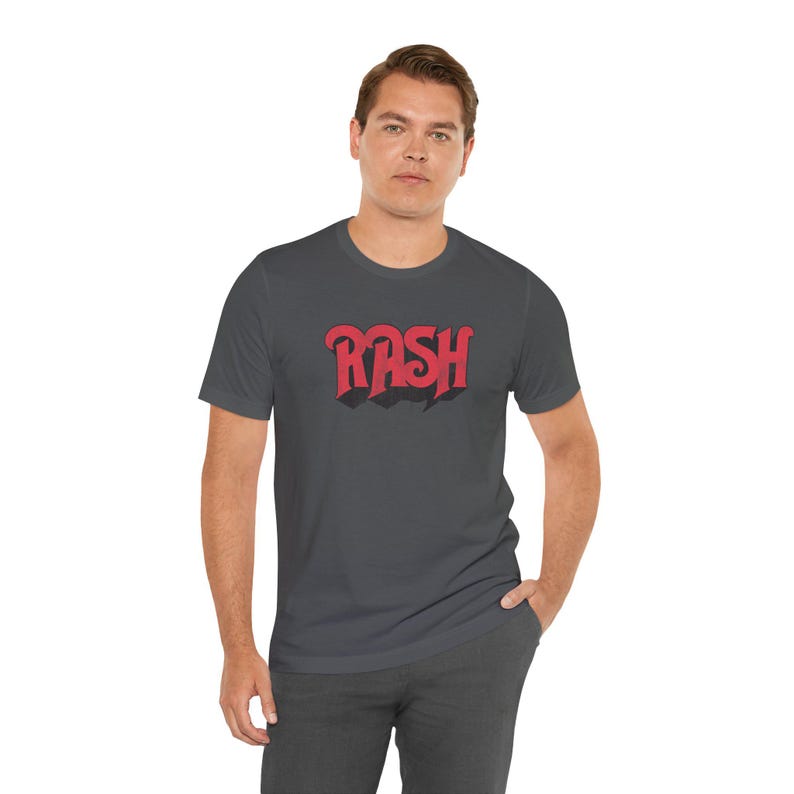 May include: A dark gray t-shirt with a red graphic of the word "RASH" in a retro font.