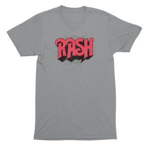 May include: A heather grey t-shirt with a red and black graphic of the word "RASH" in a retro font.