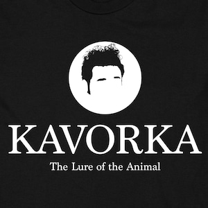 May include: Black t-shirt featuring a white silhouette of a person's head within a circle. The text "KAVORKA The Lure of the Animal" is printed beneath the image.