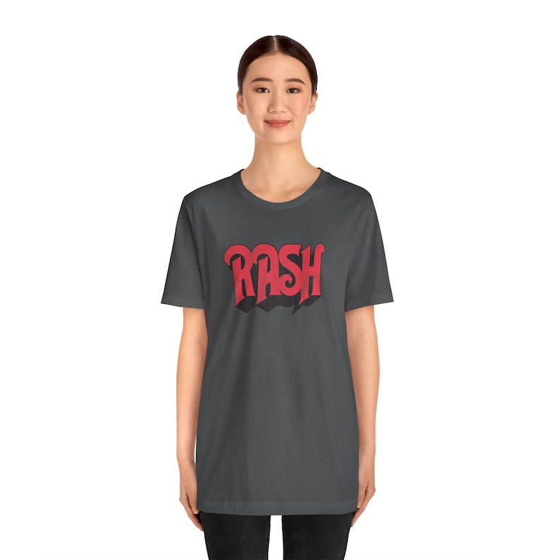 May include: A dark gray t-shirt with a red graphic of the word "RASH" in a stylized font.