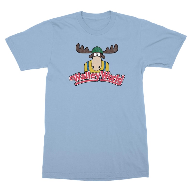 May include: Light blue t-shirt with a cartoon moose wearing a green hat and a yellow shirt. The text "Wally World" is printed in red and white below the moose.