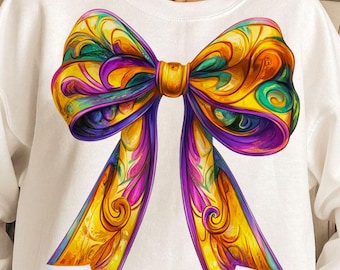 May include: White sweatshirt with a colorful bow design. The bow is made up of yellow, purple, green, and pink colors. The bow has a detailed, ornate design.