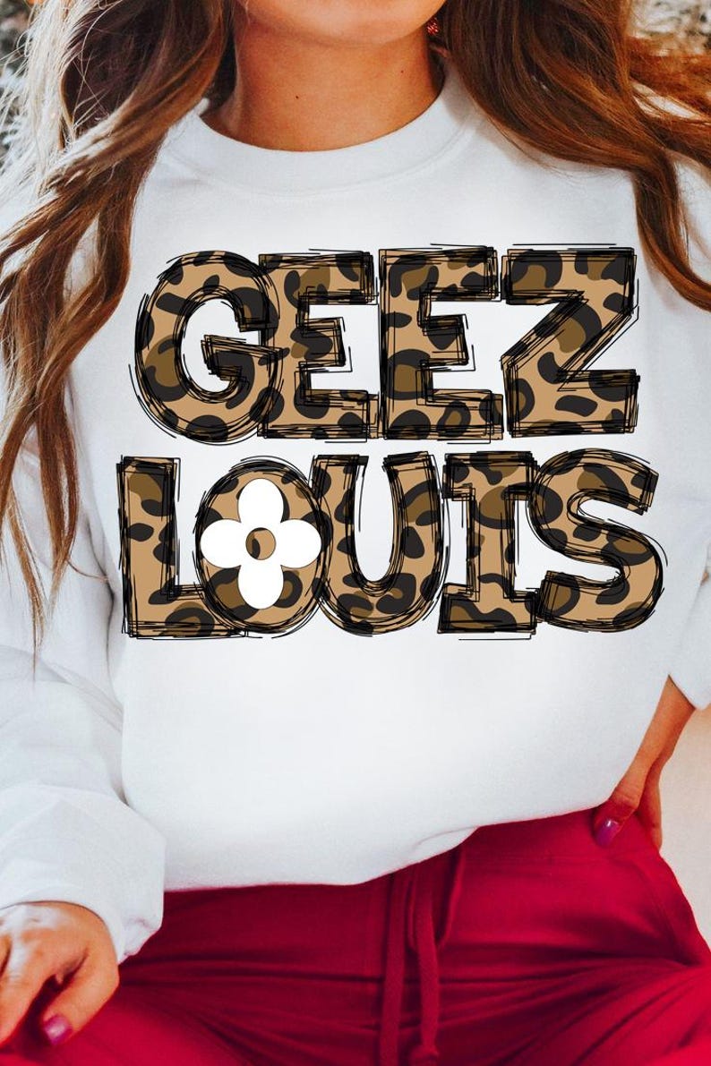 May include: White sweatshirt with a leopard print design that says "Geez Louis" with a white flower in the middle of the word "Louis".
