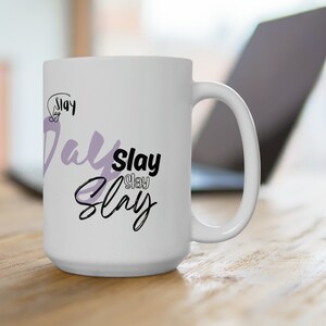 May include: White ceramic mug with a black and purple design that says "Slay Day Slay".