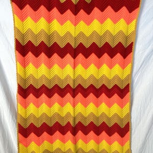 Vintage zig zag pattern afghan in bold yellow, red, pink and tan. Excellent condition, bold hippie style, bright and cheerful! 50” x 39”