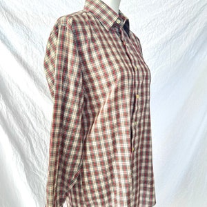 May include: A long-sleeved button-down shirt with a red, black, and white plaid pattern.