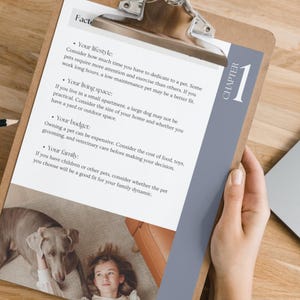 May include: A clipboard with a checklist of factors to consider when getting a pet. The checklist includes lifestyle, living space, budget, and family. The clipboard is on a wooden table with a laptop and a person's hand holding a pen.