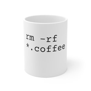 Op de afbeelding: Witte keramische mok met zwarte tekst die "rm -rf *.coffee" luidt.