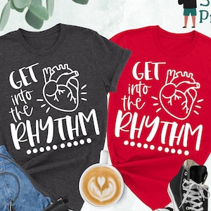 May include: Two t-shirts with the text "Get into the Rhythm" and a stylized heart graphic. The shirts are in dark heather grey and red.