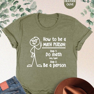 May include: A green t-shirt with a white stick figure illustration and the text "How to be a MATH PERSON: Step 1: Do math (any type) Step 2: Be a person"