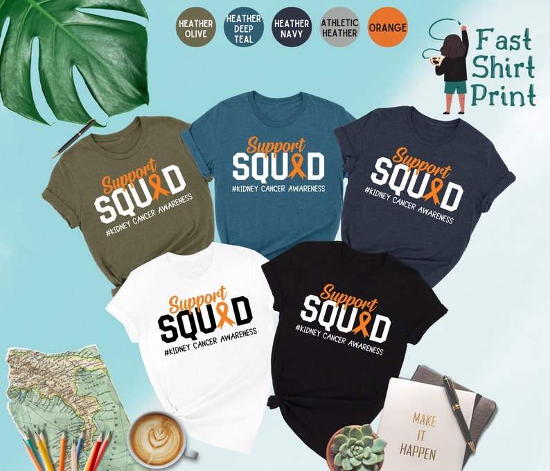 May include: Five t-shirts in different colors with the text "Support Squad" and an orange ribbon printed on the front. The text "#Kidney Cancer Awareness" is printed below the ribbon. The t-shirts are displayed on a light blue background.