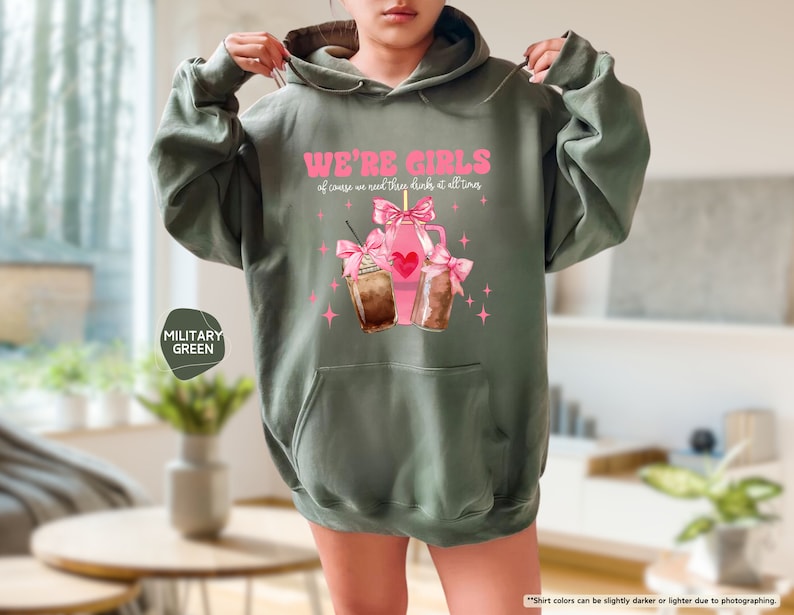 a woman wearing a green hoodie with a pink bow