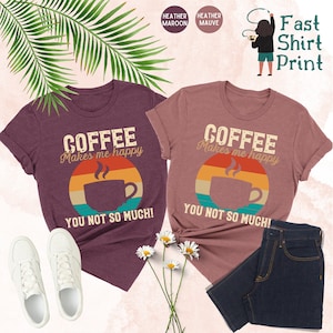 May include: Two t-shirts with a retro-style coffee cup graphic and the text "Coffee Makes Me Happy You Not So Much!" in maroon and mauve heather colors.