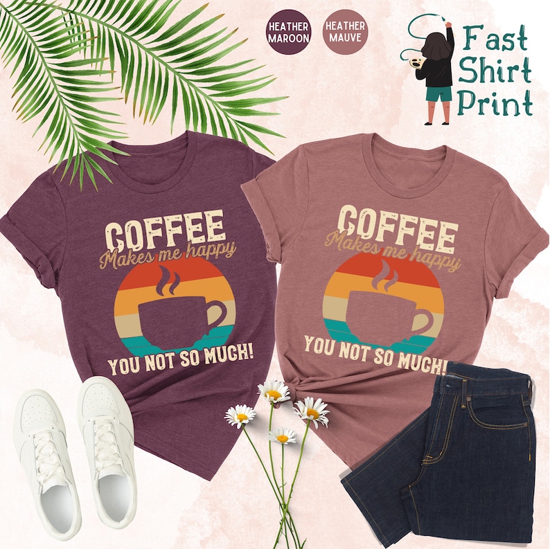 May include: Two t-shirts with a retro-style coffee cup graphic and the text "Coffee Makes Me Happy You Not So Much!" in maroon and mauve heather colors.