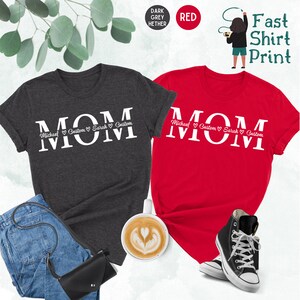 Puede incluir: Dos camisetas con la palabra "MOM" impresa en blanco sobre un fondo gris oscuro y rojo. Las camisetas tienen los nombres "Michael", "Custom", "Sarah" y "Custom" impresos debajo de la palabra "MOM".