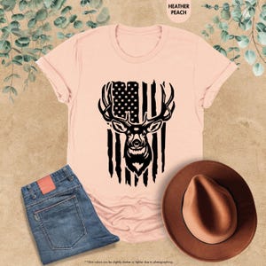 a pink shirt with an american flag and a deer's head