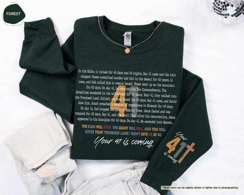 May include: A dark green sweatshirt with a white print that includes a Bible verse and the text "Your 41 is coming". The print also includes a graphic of a cross with the number 411.
