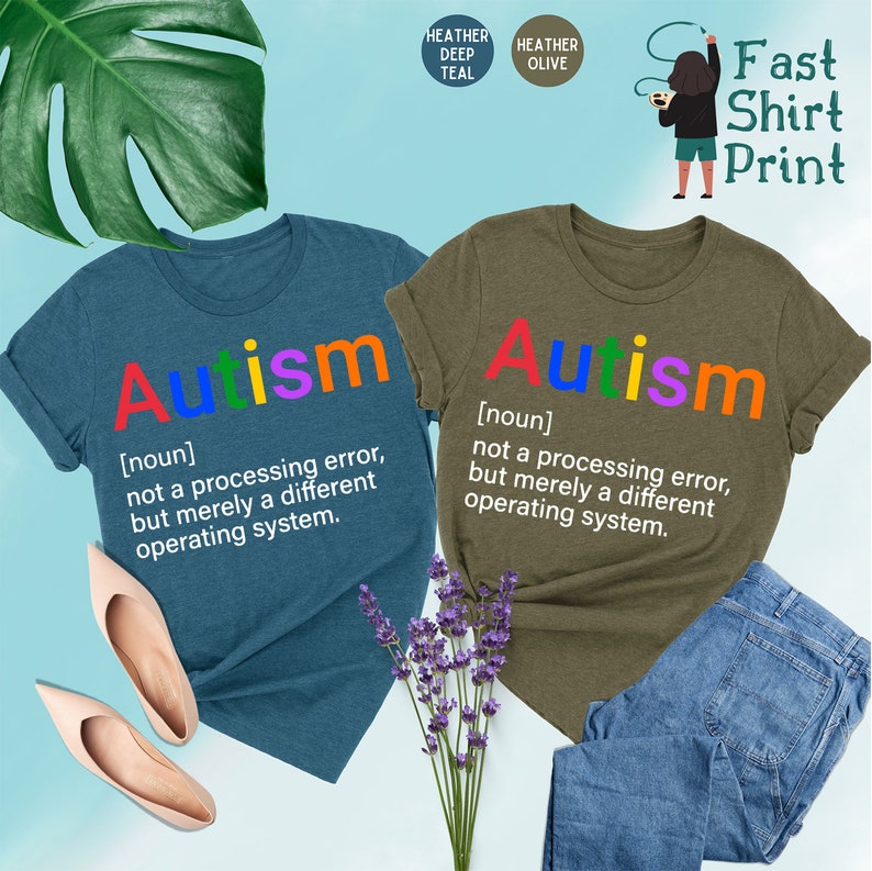 May include: Two t-shirts with the word "Autism" printed in rainbow colors. The text below the word defines autism as "not a processing error, but merely a different operating system."