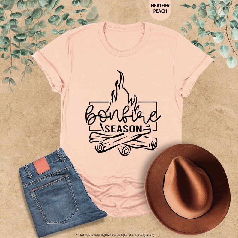 a t - shirt that says bonfire season next to a cowboy hat