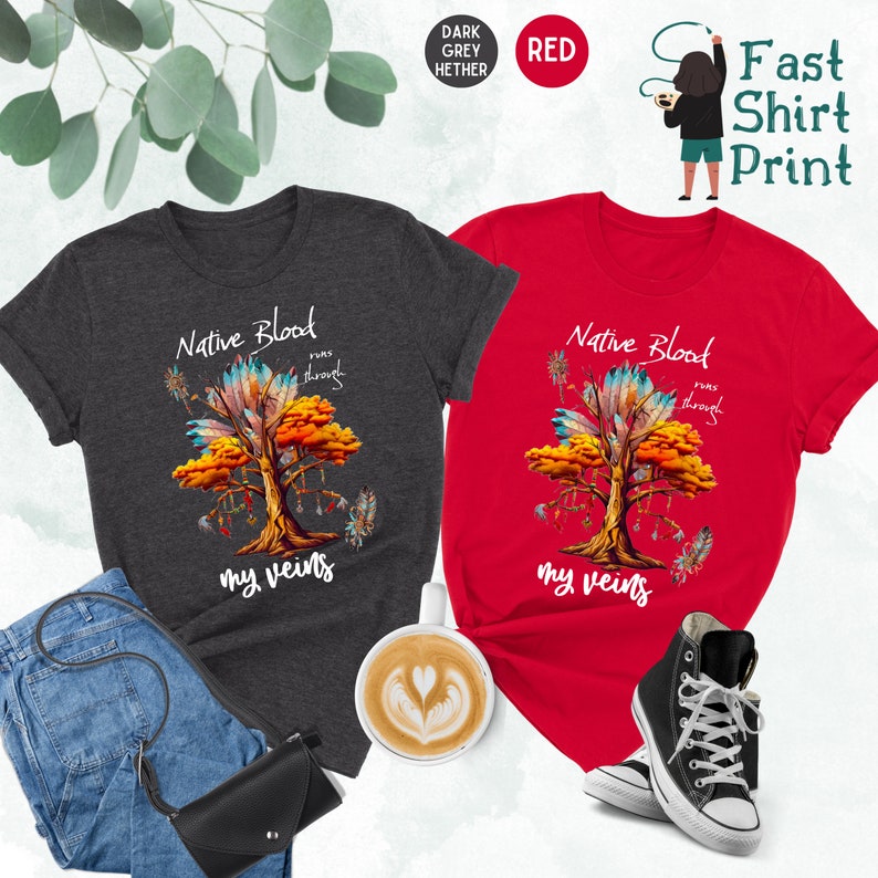 May include: Two t-shirts with a Native American design. The design features a tree with feathers and the text "Native Blood runs through my veins". One shirt is dark heather grey and the other is red.