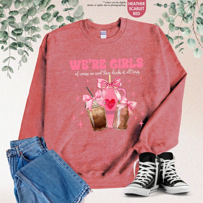 K&ouml;nnte beinhalten: Ein heidefarbenes, scharlachrotes Sweatshirt mit dem Text "We're Girls of course we need three drinks at all times" und einer Grafik von drei mit rosa Schleifen verzierten Einmachgl&auml;sern mit Strohhalmen und Herzen.