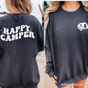 May include: Dark heather gray sweatshirt with the words "HAPPY CAMPER" in white on the back. A white camper graphic is on the front. The sweatshirt is a comfortable, casual style.