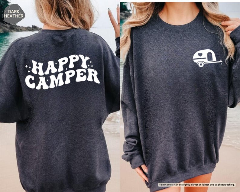 May include: Dark heather gray sweatshirt with the words "HAPPY CAMPER" in white on the back. A white camper graphic is on the front. The sweatshirt is a comfortable, casual style.