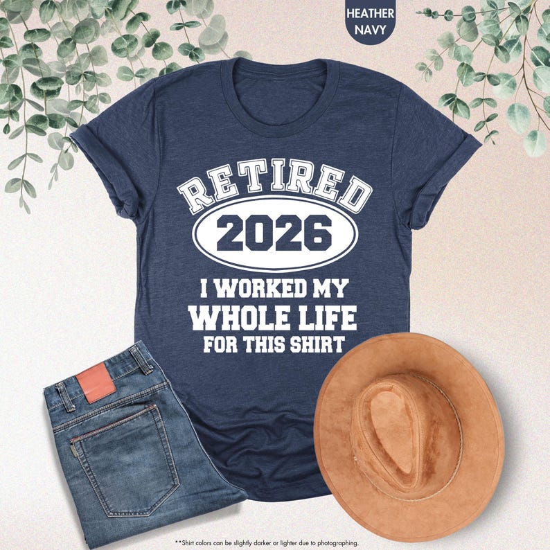 Puede incluir: Camiseta azul marino jaspeada con el texto "RETIRED 2026 I WORKED MY WHOLE LIFE FOR THIS SHIRT". La imagen tambi&eacute;n muestra unos vaqueros azules y un sombrero marr&oacute;n.
