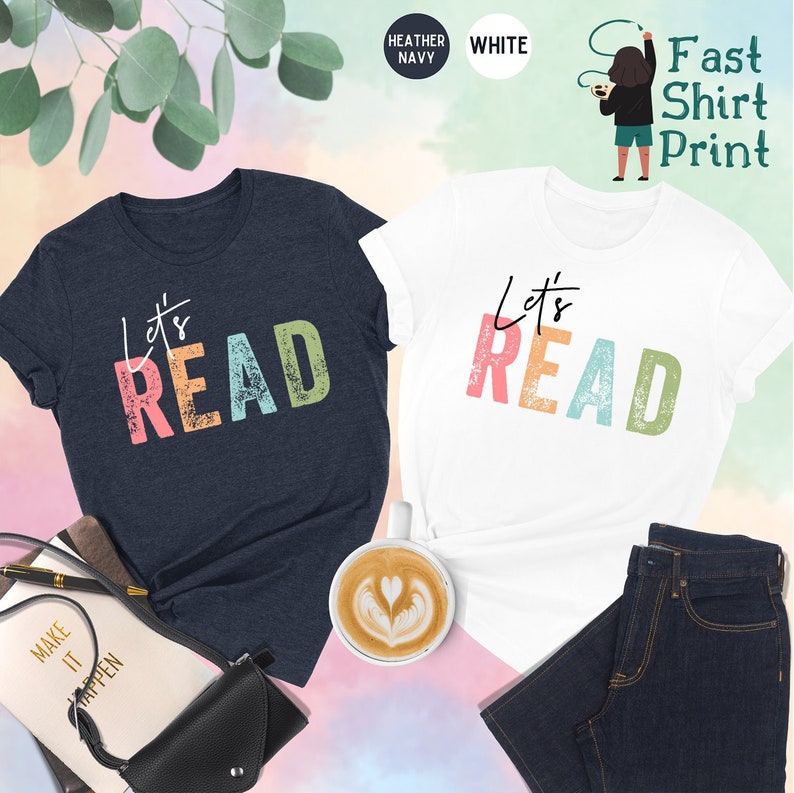 May include: Two t-shirts with the text "Let's Read" in colorful letters. The shirts are in heather navy and white.