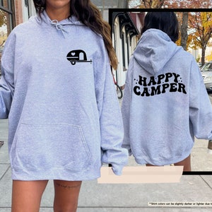 a woman wearing a grey happy camper hoodie