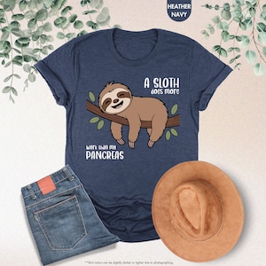 K&ouml;nnte beinhalten: Heather-marineblaues T-Shirt mit einem Cartoon-Faultier-Motiv. Das braune Faultier h&auml;ngt an einem Ast. Der Text auf dem Shirt lautet: "Ein Faultier arbeitet mehr als meine Bauchspeicheldr&uuml;se."