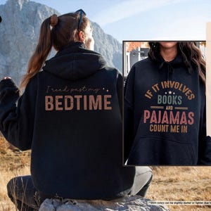 Puede incluir: Sudadera con capucha negra con el texto "I read past my bedtime" en la parte delantera. Otra sudadera con capucha negra con el texto "If it involves books and pajamas count me in" en la parte delantera.
