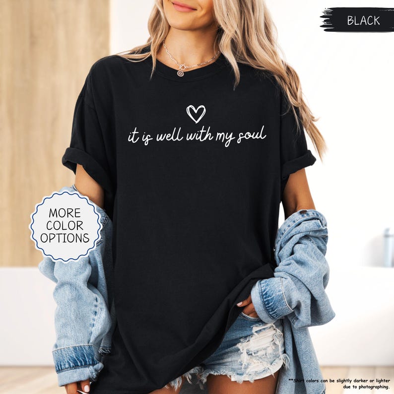K&ouml;nnte beinhalten: Schwarzes T-Shirt mit dem wei&szlig;en Schriftzug "it is well with my soul" und einem Herz. Das Bild deutet auf weitere verf&uuml;gbare Farben hin. Teil einer Bekleidungskollektion.