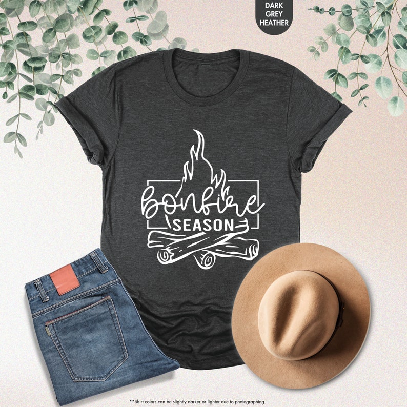a t - shirt that says bonfire season next to a hat and jeans