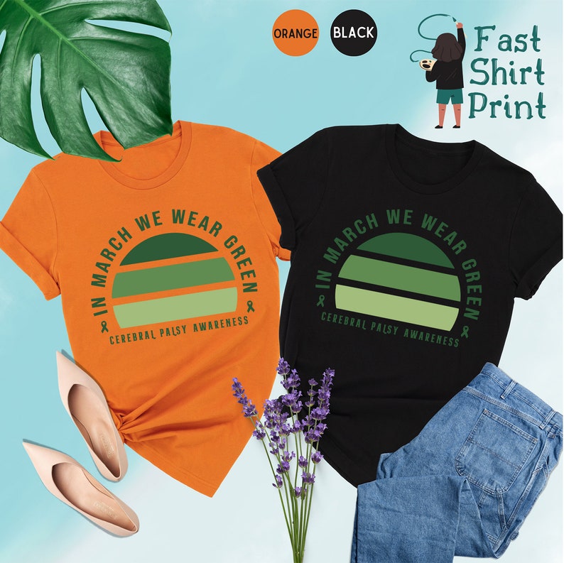 May include: Two t-shirts with a green and white striped graphic that says "In March We Wear Green" and "Cerebral Palsy Awareness". One shirt is orange and the other is black.