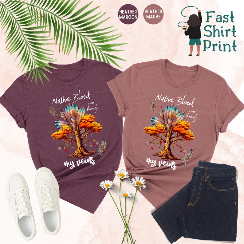 May include: Two heather colored t-shirts with a Native American inspired tree design. The text on the shirts reads "Native Blood runs through my veins".