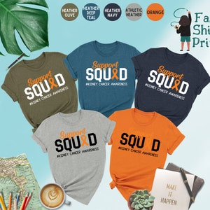 May include: Five t-shirts in different colors with the text "Support Squad" and a ribbon graphic. The text "#Kidney Cancer Awareness" is below the graphic. The t-shirts are heather olive, heather deep teal, heather navy, athletic heather, and orange.