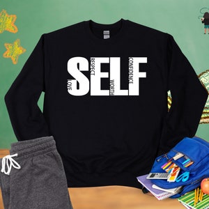 May include: Black sweatshirt with white text that reads "SELF" with the words "CONFIDENCE", "WORTH", "RESPECT", and "LOVE" written vertically around the letters.