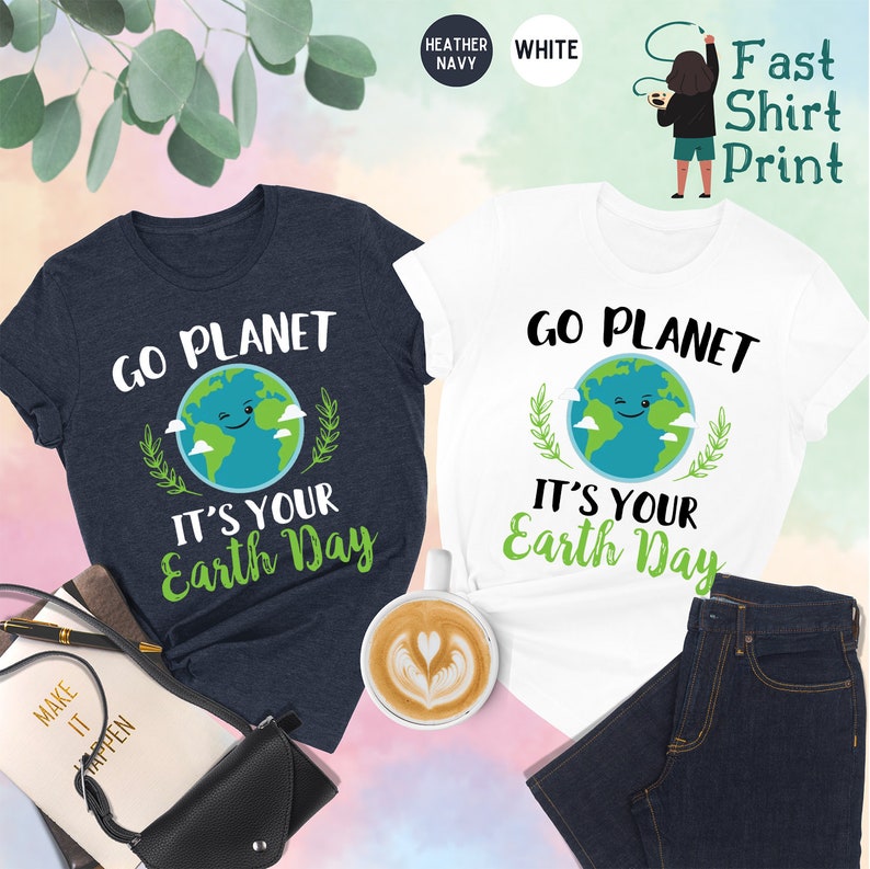 May include: Two t-shirts with a graphic of a smiling earth with clouds and leaves. The text on the shirts reads "Go Planet It's Your Earth Day". The shirts are available in heather navy and white.