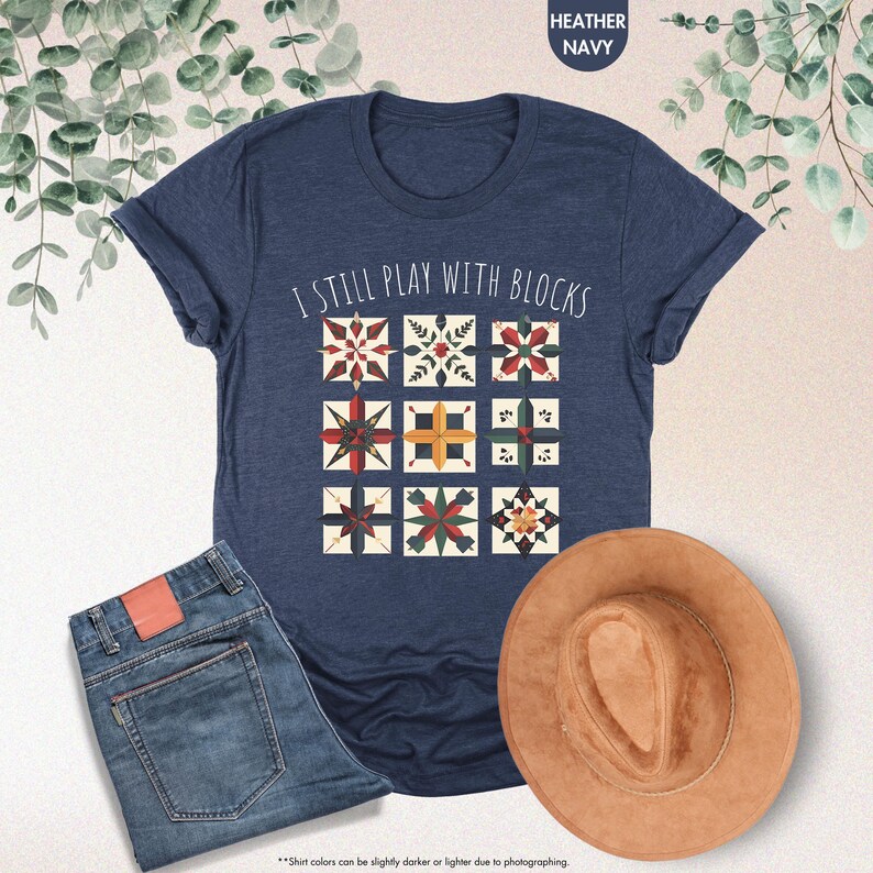 May include: A navy blue t-shirt with the text "I still play with blocks" and a graphic of colorful quilt blocks.