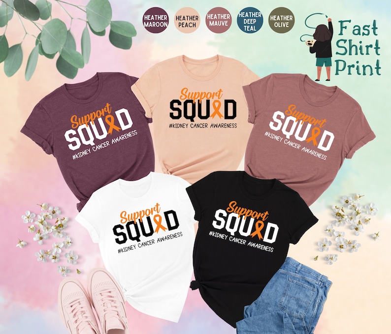 May include: Five t-shirts in different colors with the text "Support SQUAD #KIDNEY CANCER AWARENESS" printed on them. The shirts are displayed on a white background with flowers and a pair of pink shoes.
