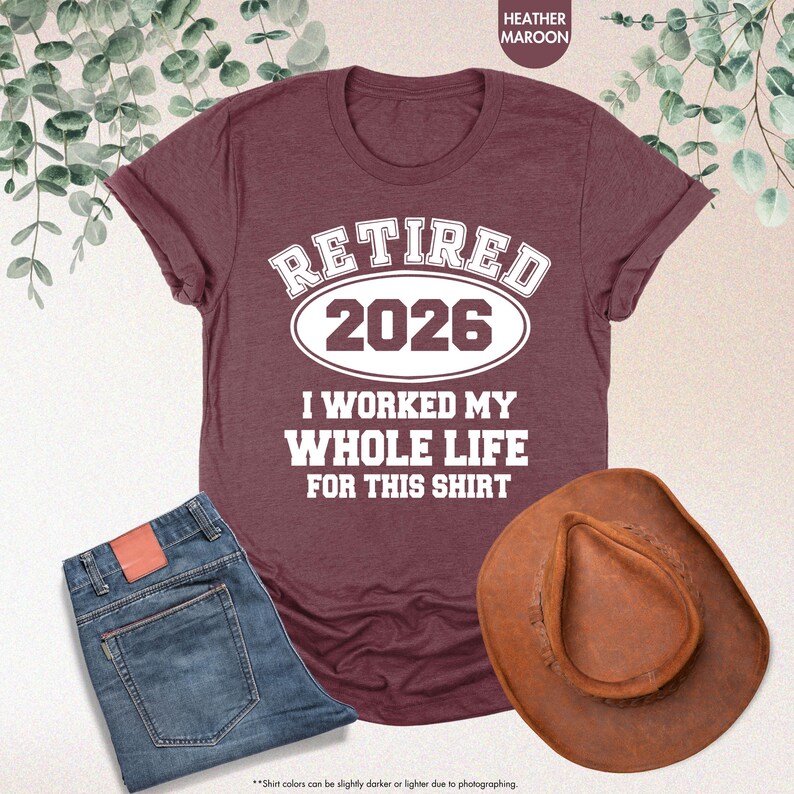 Puede incluir: Camiseta granate con el texto "RETIRED 2026 I WORKED MY WHOLE LIFE FOR THIS SHIRT". La imagen tambi&eacute;n muestra unos vaqueros azules y un sombrero de vaquero marr&oacute;n. La camiseta es de color granate jaspeado.