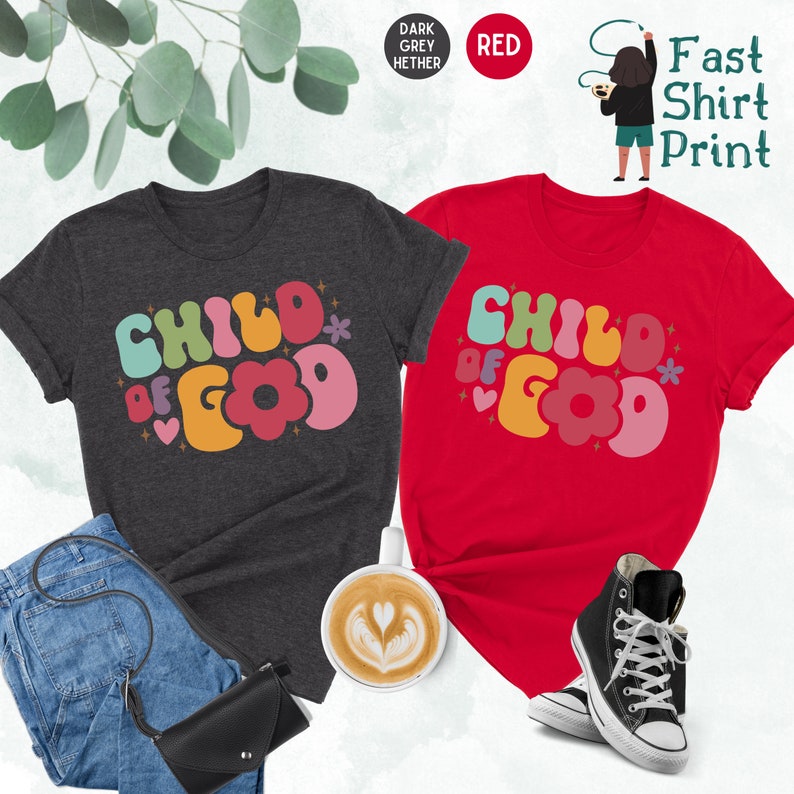Op de afbeelding: Twee T-shirts met de tekst "Child of God" in kleurrijke, retro-stijl letters. De shirts zijn in donker grijs melange en rood.